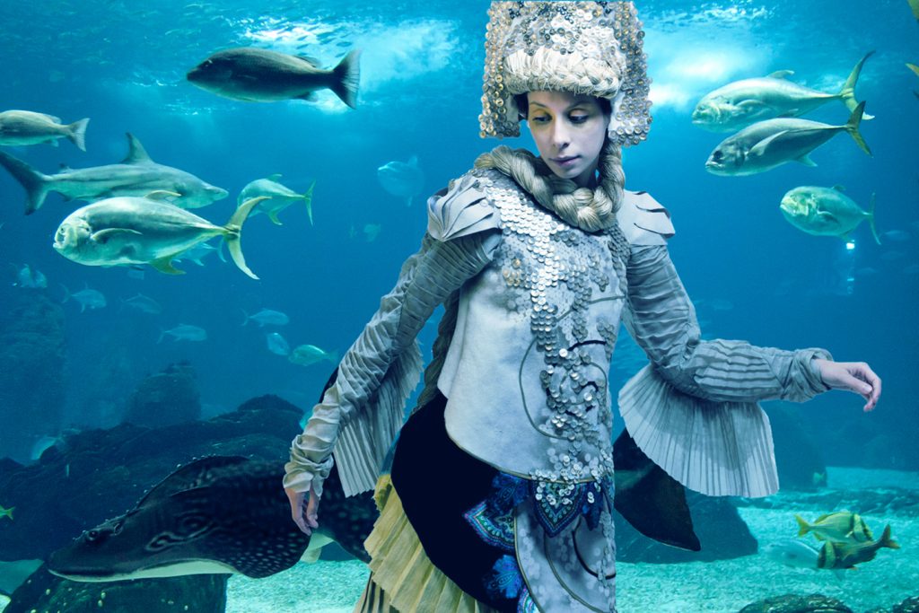 Girl in fairytale costume in fish tank