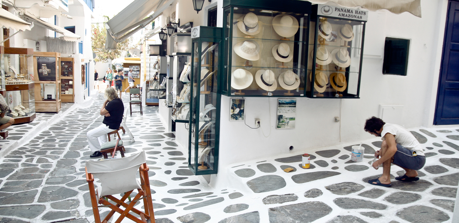 Mykonos street with white painted tiles borders