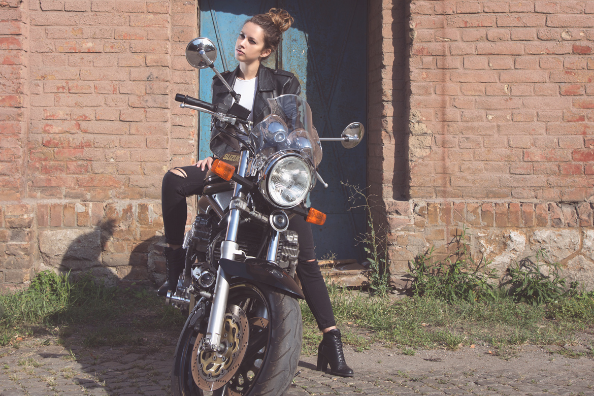 Girl on a motorbike with blue doors behind