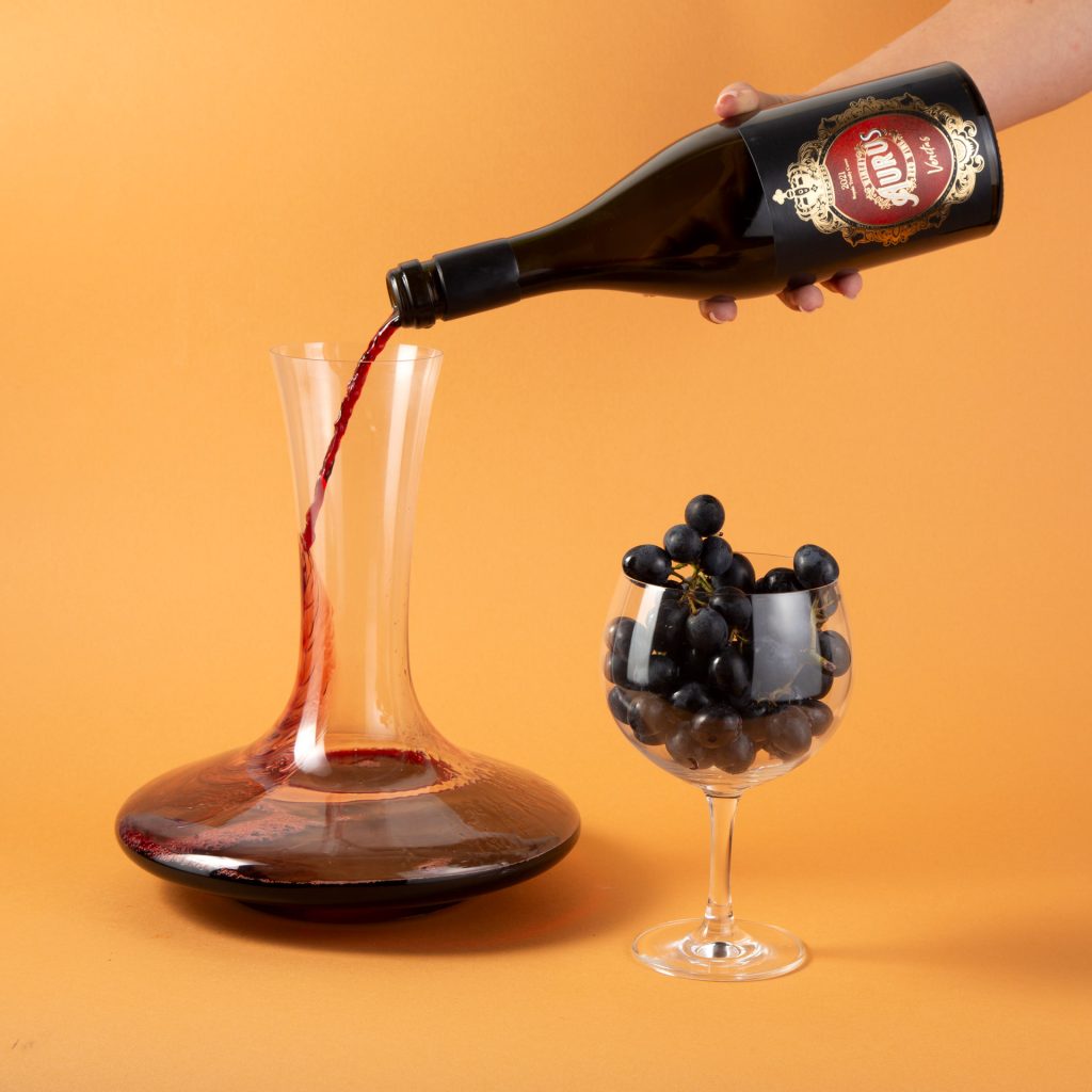 Bottle of red wine with Wine glass and grapes on yellow background